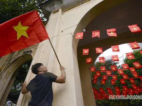 Cờ Tổ quốc rực rỡ trước cổng làng giữa phố phường Hà Nội