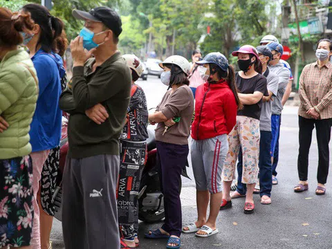 Người dân đeo khẩu trang, cầm nước rửa tay đến xếp hàng mua bánh trôi