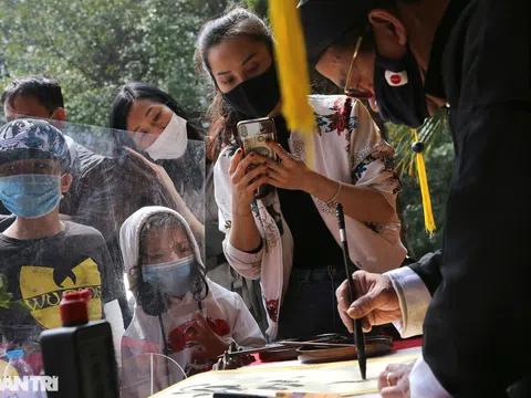 Ông đồ thời covid-19 đeo khẩu trang cho chữ đầu xuân qua vách ngăn