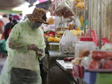 Người dân mặc áo mưa, trùm kín khi đi chợ giữa nắng 37 độ C