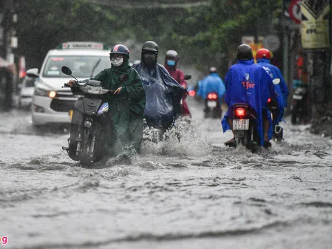 Người dân TP.HCM dắt bộ xe máy đi làm trong mưa lớn