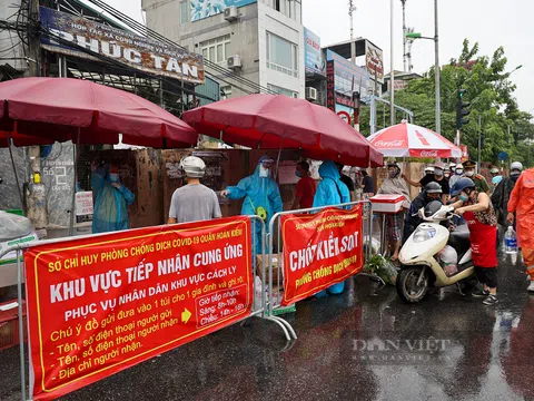 Hàng dài người dân xếp hàng dưới mưa gửi đồ tiếp tế vào khu vực phong tỏa